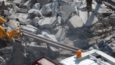 Eavy machines working in teamwork to clean broken concrete by digging and dri Stock Footage 129598619