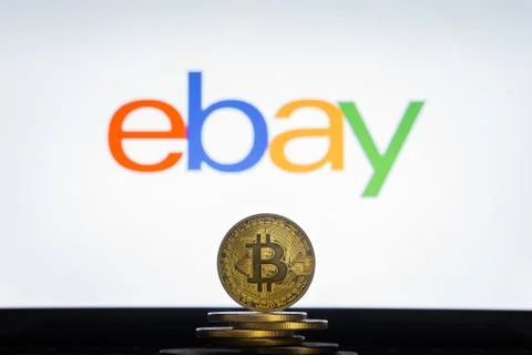 Ebay logo on a computer screen with a stack of Bitcoin cryptocurency coins. Stock Photos