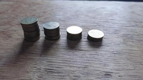 The Ebbing Flow of Wealth: Visualizing the Gradual Decrease of Coin Stacks Stock Photos