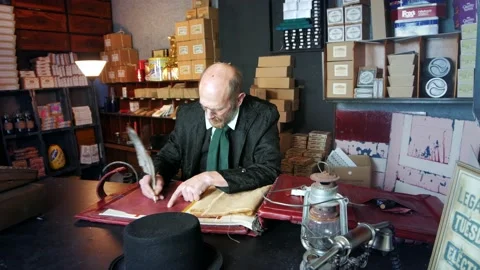 Ebeneezer Scrooge in his counting house shop. The man is in Victorian Stock Footage 143369122