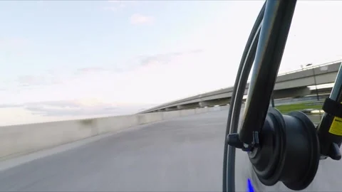 Ebike with blue lights moves fast on path under bridge, low pov shot Stock Footage 157422792