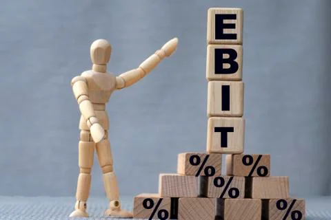 EBIT , the word is on cubes on a gray background, next to it is a wooden man. Stock Photos