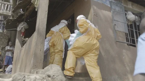 EBOLA: Response workers carry corpse from house in body bag Video stock 90337367