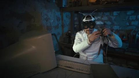 Eccentric man in large goggles tests electronics in a basement. Video stock 329511872