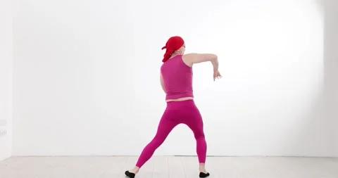 Eccentric man performer in pink activewear stretches vigorously Stock Footage 310215403
