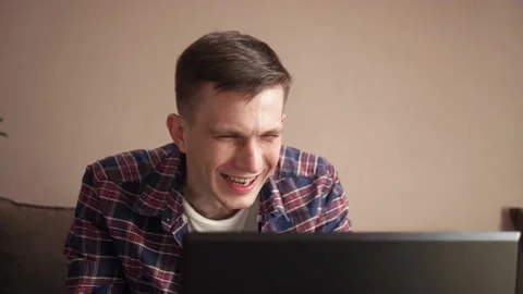 Eccentric young man laughing while chatting via video call. Video stock 211812282