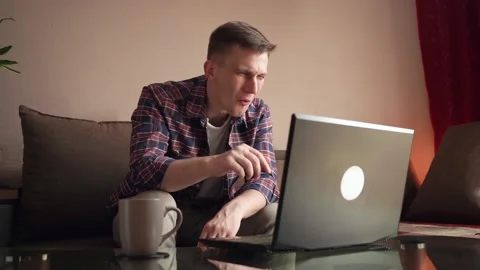 Eccentric young man laughing while chatting via video call. cozy home Stock Footage 212608748