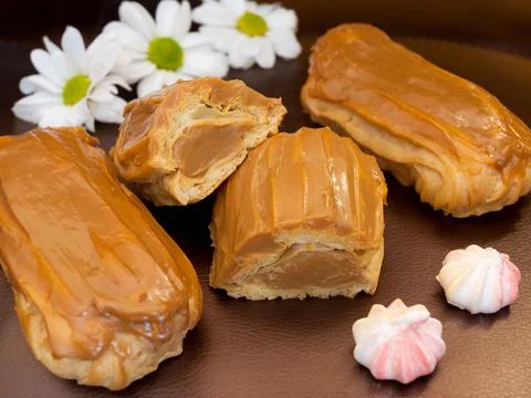 Eclair with boiled condensed milk on a dark background Stock Photos