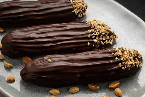 Eclair cake with custard and nuts. Close-up Stock Photos
