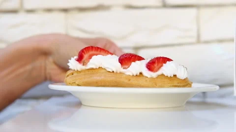 Eclair cake decorated with cream and strawberry berries Stock Footage 219535372