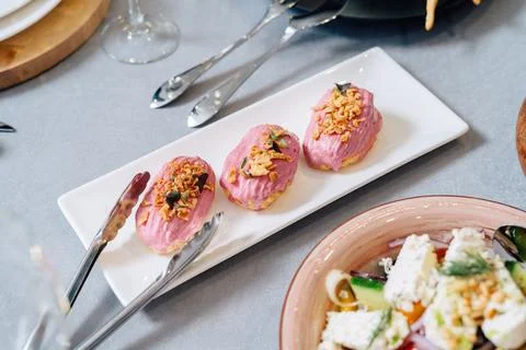 Eclair cakes. Eclair custard cakes with cream and raspberries covered with pink Photos