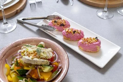 Eclair cakes. Eclair custard cakes with cream and raspberries covered with pink 스톡 사진