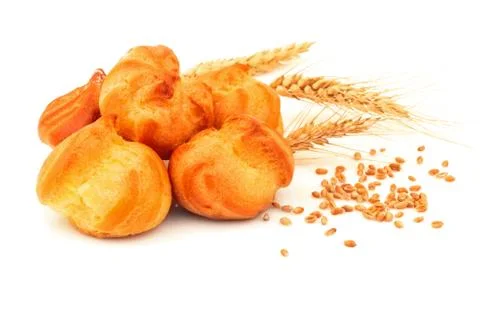 Eclair custard cake profiterole bread with wheat spike and seeds. Isolated on Stock Photos