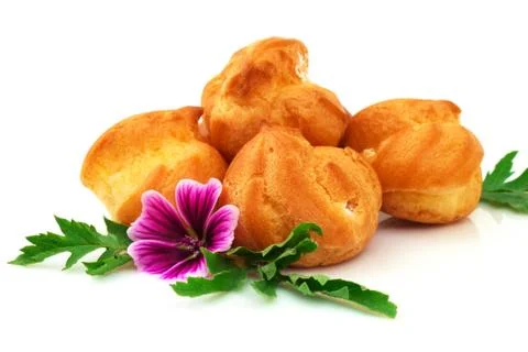 Eclair, custard, cake, profiterole with violet flower. Isolated on white back Stock Photos