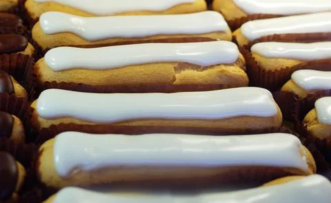 Eclair with custard on the window of a pastry shop. Stock Photos