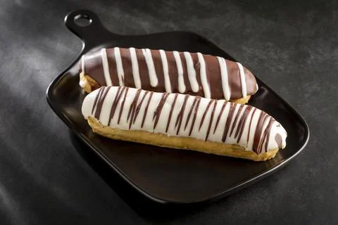 Eclair. Tasty chocolate eclair on the table. Stock Photos