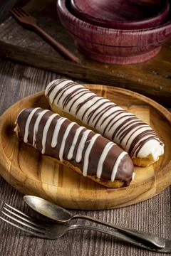 Eclair. Tasty chocolate eclair on the table. Stock Photos