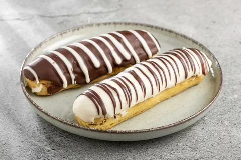 Eclair. Tasty chocolate eclair on the table. Stock Photos