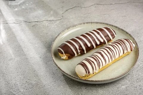 Eclair. Tasty chocolate eclair on the table. Stock Photos
