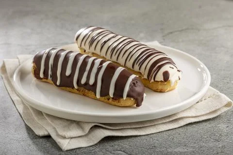 Eclair. Tasty chocolate eclair on the table. Stock Photos