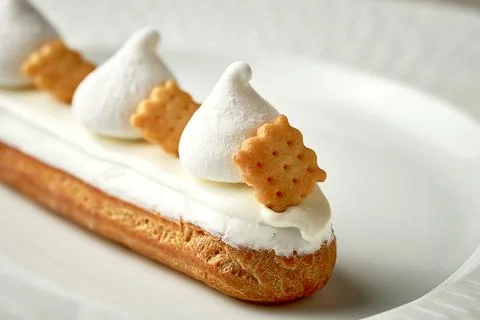 Eclair with white frosting and custard. Selective focus, close-up Stock Photos