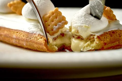Eclair with white frosting and custard. Selective focus, close-up Stock Photos