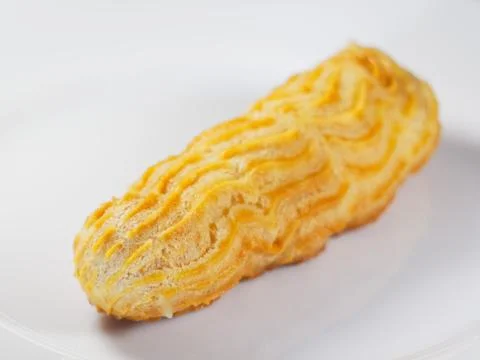 Eclair without glaze on a white background. Close-up. Foto stock