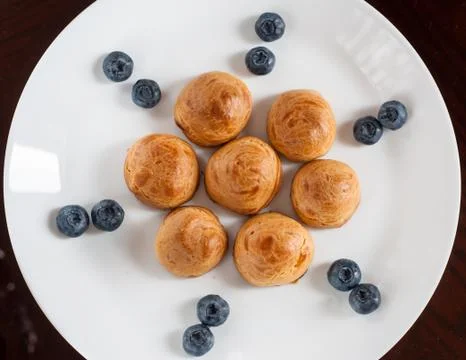 Eclairs with blueberries Stock Photos