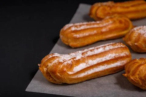 Eclairs with cream on a dark background Stock Photos