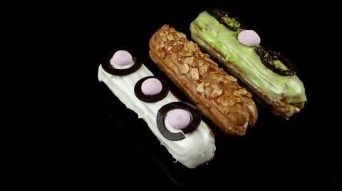 Eclairs with glaze, chocolate, nuts and pistachios no top, loop Stock Footage 63853321