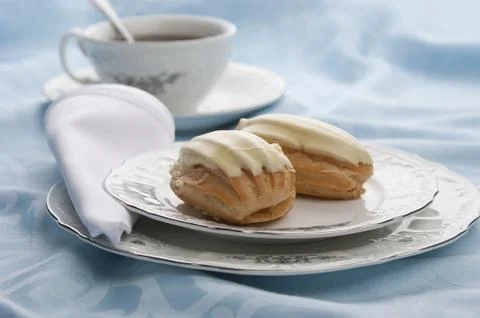 Eclairs with tea Stock Photos