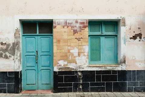 Eclectic Facade with Mixed Materials, Green Windows, and Layered Urban Decay Stock Photos