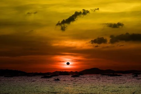 Eclipse on the sunset sky on the sea and silhouette speed boat Stock Photos