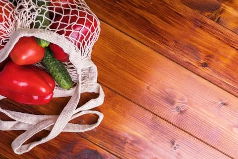 Eco bag string bag with vegetables cucumbers and tomatoes on a wooden background Stock Photos