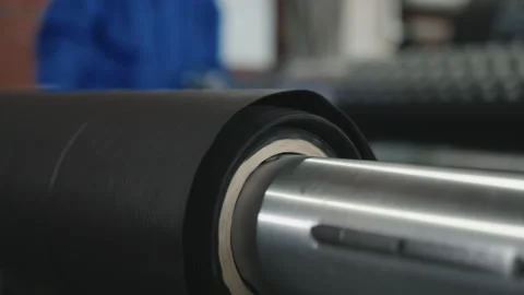 Eco fabric material spinning on a roller shaft attached to processing equipment Stock Footage 202535583