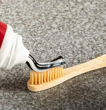 Eco-friendly activated charcoal toothpaste applied to a bamboo toothbrush Stock Photos