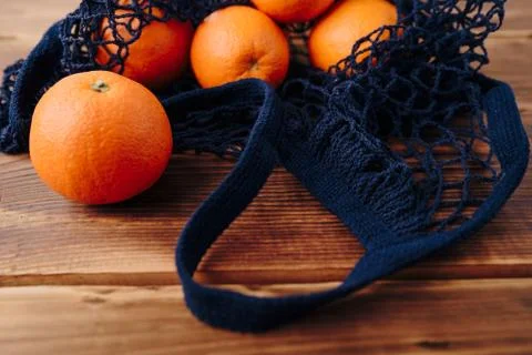 Eco- friendly bag string bag with oranges on a wooden background Foto stock