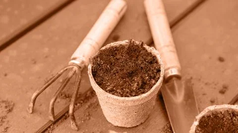 Eco friendly biodegradable peat pots and garden tools. Image toned in Peach Fuzz Stock Photos