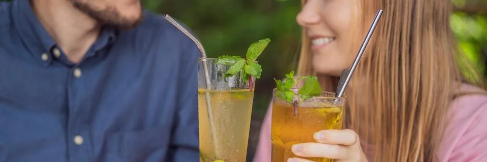 Eco friendly couple using reusable stainless steel straw to drink fruit tea Stock Photos