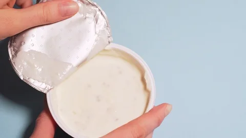 Eco-friendly curd cream with in coconut milk. Female hands tear off the lid from Stock Footage 126213673