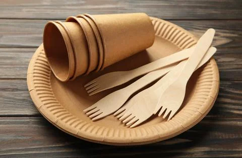 Eco friendly disposable tableware on a brown background. Stock Photos