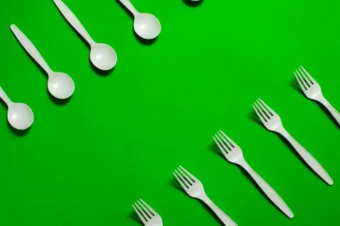 Eco-friendly disposable tableware on a green background. Stock Photos