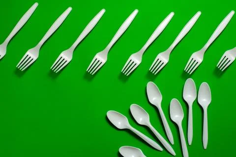 Eco-friendly disposable tableware on a green background. Stock Photos