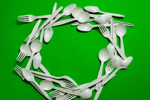 Eco-friendly disposable tableware on a green background. Stock Photos