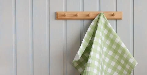 Eco-friendly kitchen background, design. green checkered towel hangs on a wooden Stock Photos