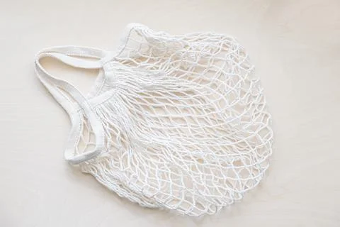 Eco friendly mesh bag on a light wooden background Stock Photos