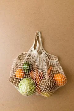 Eco friendly reusable mesh string knitted shopping bag with fruits and Stock Photos