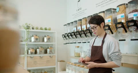 Eco friendly shop owner checking organic products stock in container dispenser. Video stock 233785414