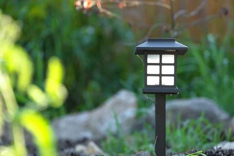 Eco-friendly solar path lantern, perennial flowerbed with daylilies, grasse.. Stock Photos