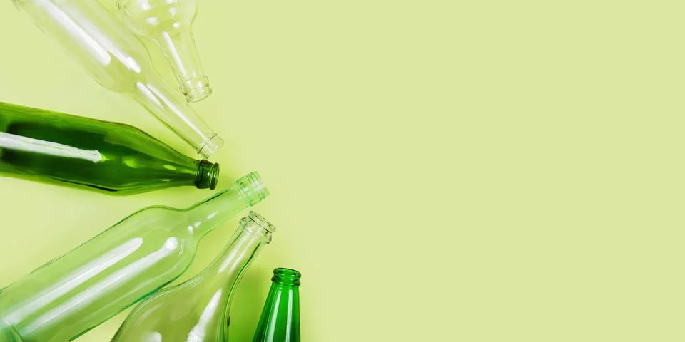 Eco-friendly waste sorting with clear and green bottles Foto stock